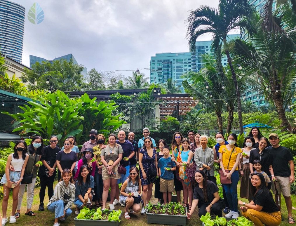 Around thirty-five workshop participants of all ages in the Rockwell garden with planted trays