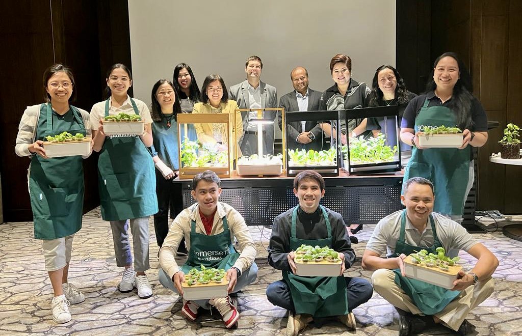Ascott Somerset staff in aprons holding trays of seedlings after a GIY training session