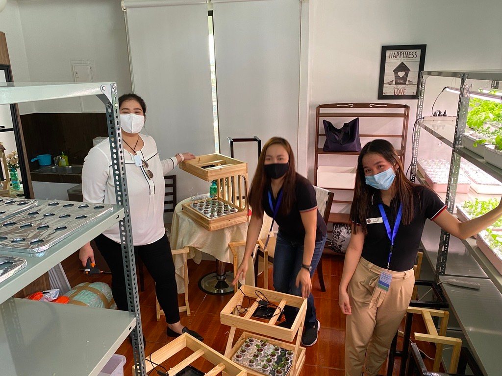 Three team members in the GIY workshop with racks and components